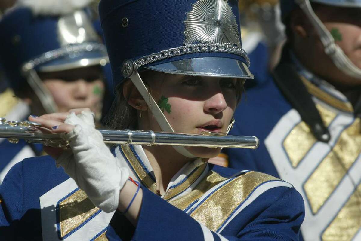 A Bunnell High School band member plays her flute, wearing a shamrock on her face, Wed., March 17, 2010, while marching in the Bridgeport St. patrick's Day Parade.