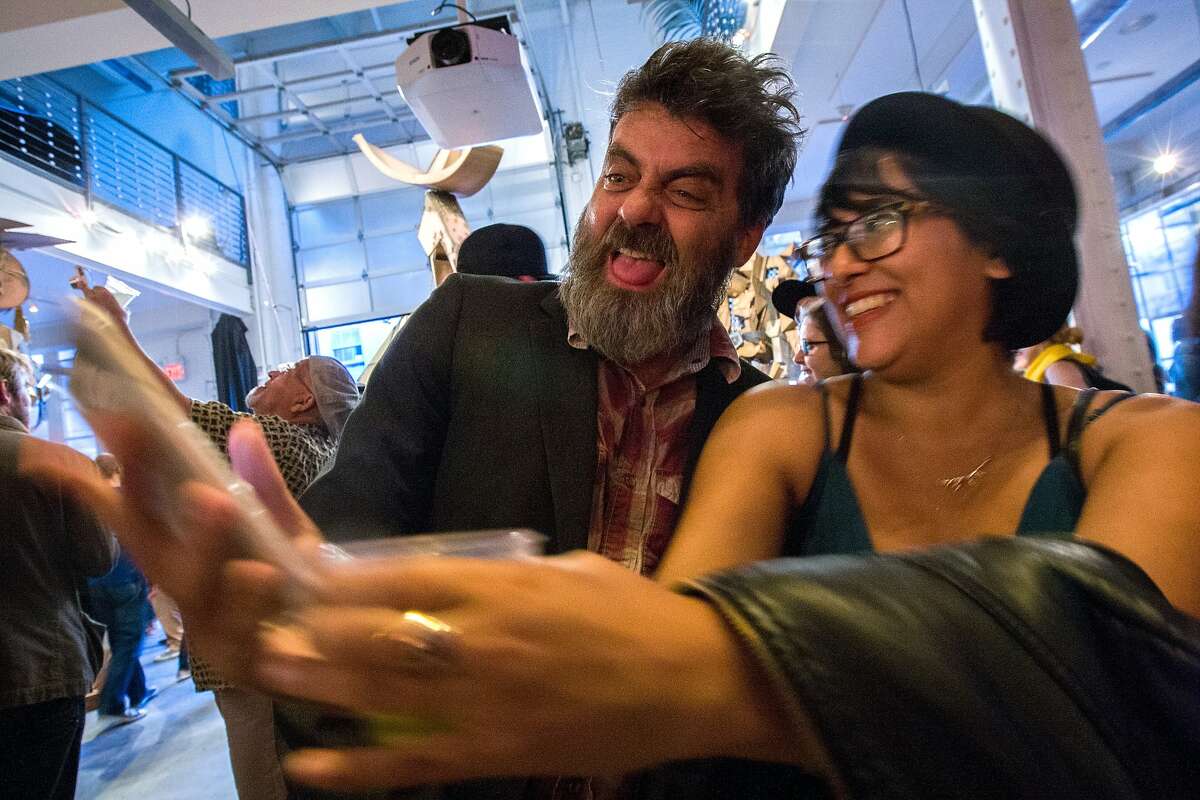 Wayne White, left, takes a photo with Aurora Alcantar during the Ass Kicking Contest exhibit, Saturday, July 11, 2015, at Heron Arts, in San Francisco, Calif.