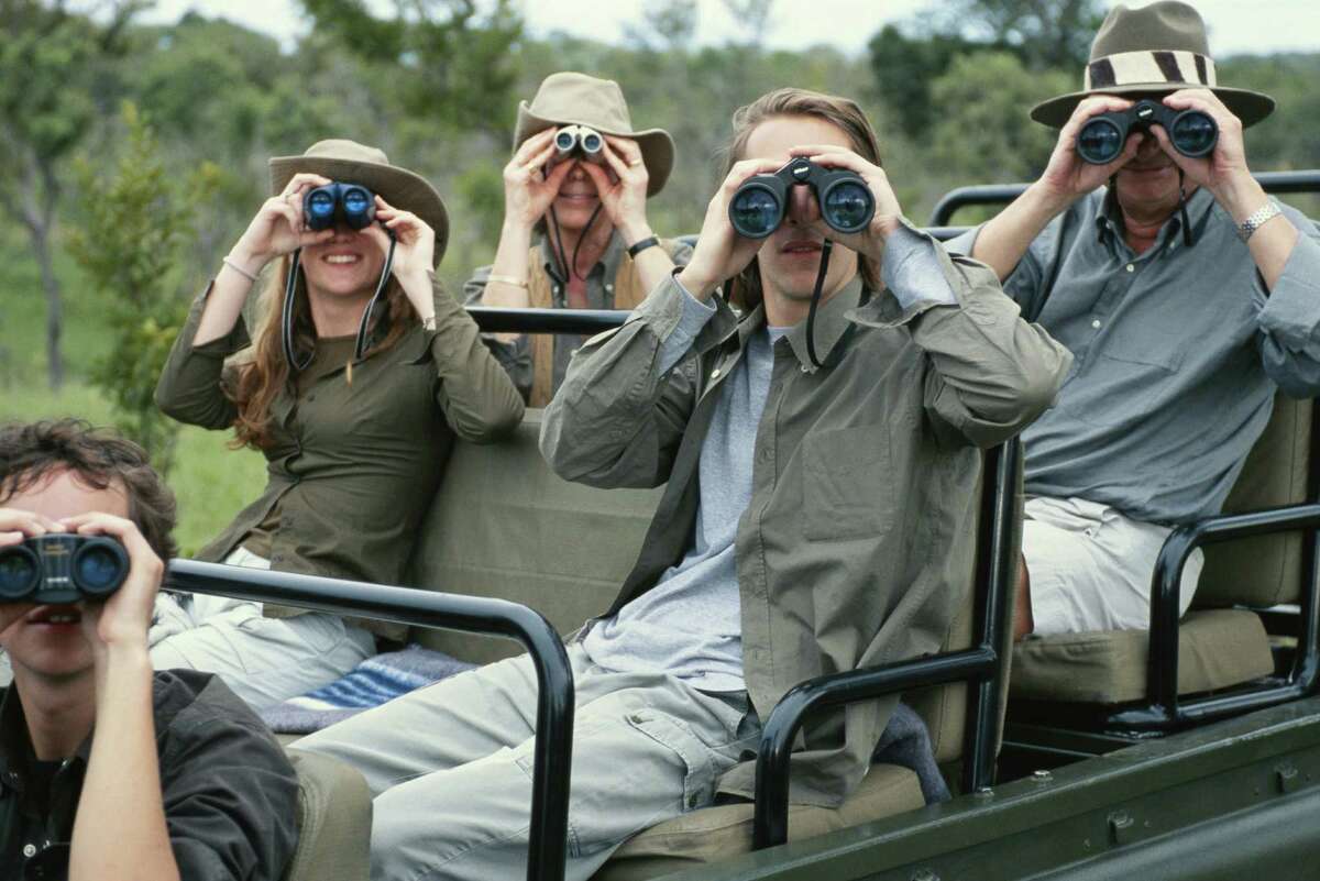 Group of friends on off road vehicle with binoculars