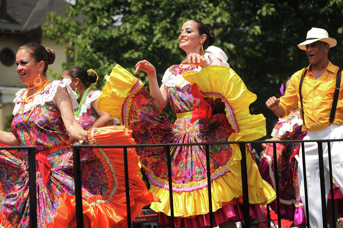 Dancers in traditional costumes dance to salsa music on one of many floats during the Puerto Rican Day Parade on Park Avenue in Bridgeport, Conn. on Sunday, July 12, 2015.