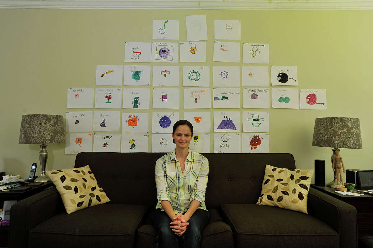 Wendy Skratt poses for a photograph in front of her childrens' artwork on the wall at her home in Stamford, Conn., on Friday, July 10, 2015. Skratt moved to Stamford from Brooklyn, NY, in 2005. She is currently the president of the League of Women Voters.
