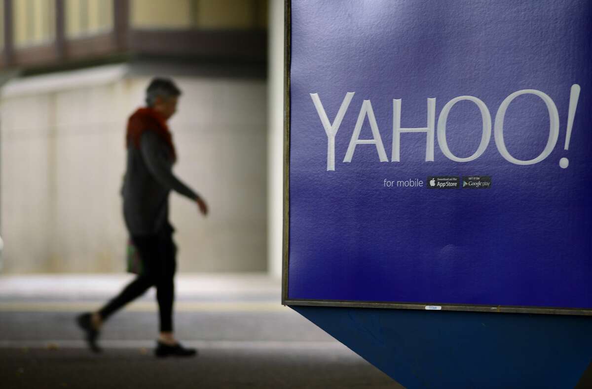 A pedestrian walks under the Rockridge BART Station passing a Yahoo ad in Oakland, California, on Tuesday, July 14, 2015.