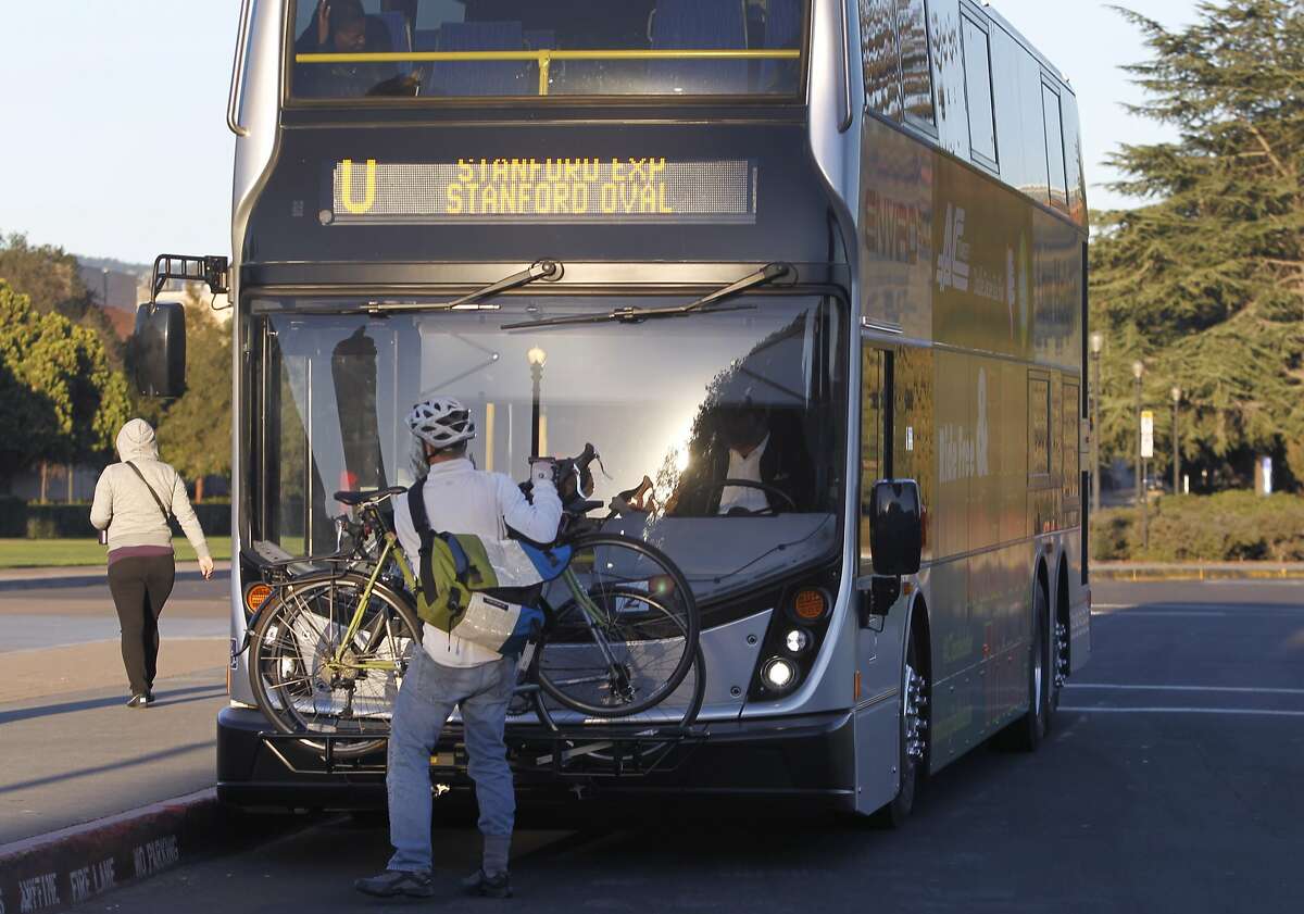 A man removes his bicycle at Stanford University after commuting from Fremont, Calif. on Tuesday, Feb. 24, 2015. AC Transit tested the 80-seat double-decker buses to meet growing ridership demand.
