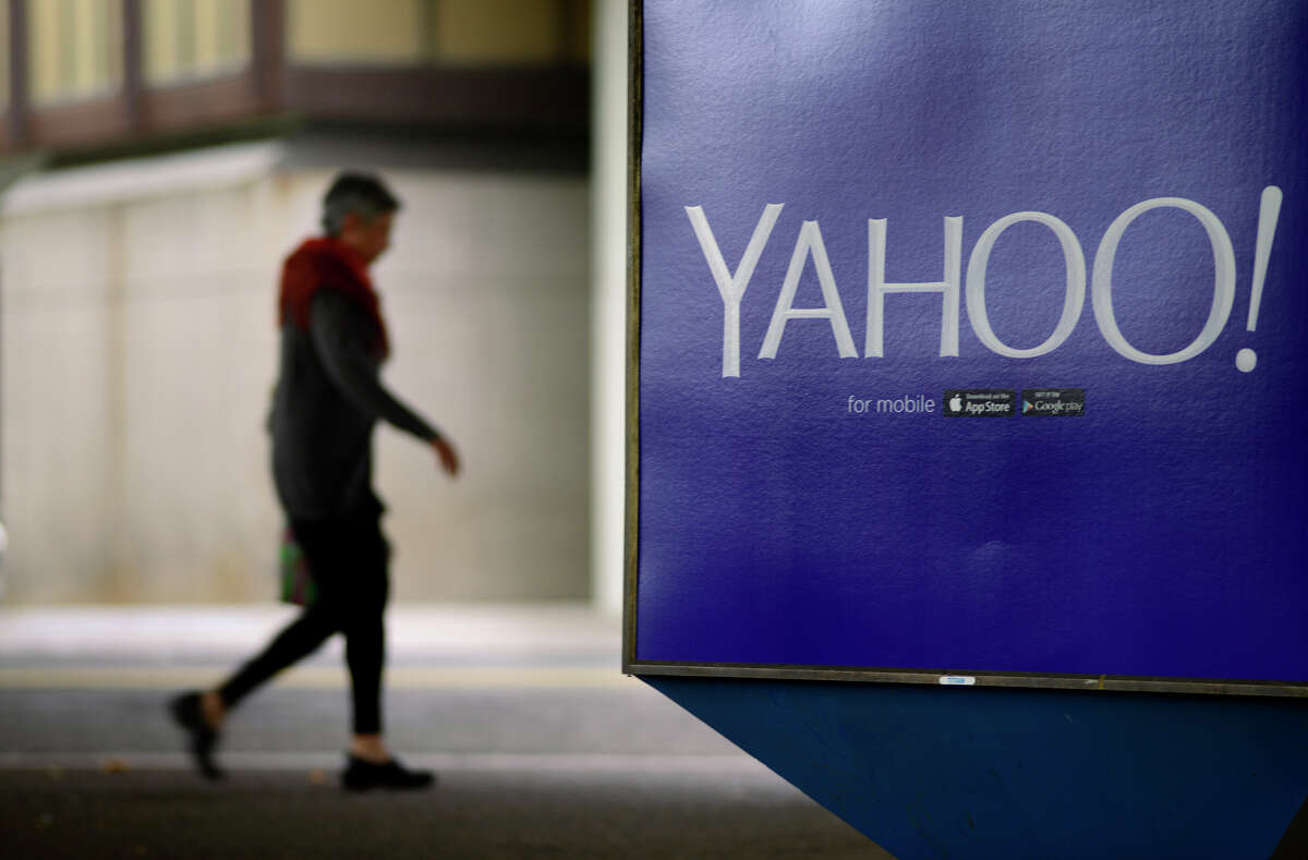 A pedestrian walks under the Rockridge BART Station in Oakland, passing one of the Yahoo ads promoting its mobile services.