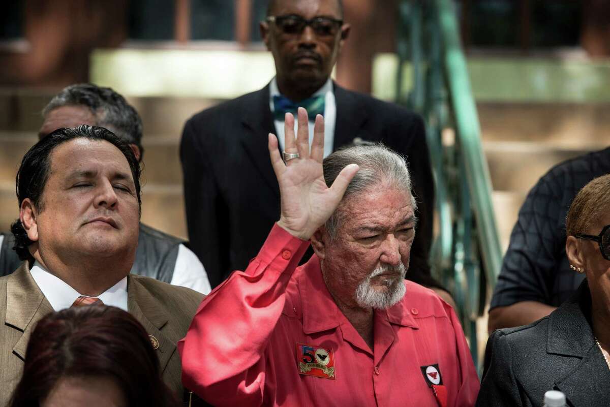 Jaime Martinez, center, CEO and founder of the Cesar E. Chavez Legacy and Educational Foundation, prays during a press conference on the steps of city hall, held by a coalition of several San Antonio groups to call for San Antonio City Manager Sheryl Sculley to hire Interim Police Chief Anthony Trevino, a San Antonio native, who has worked on the force for 22 years, instead of looking across the nation for candidates, on Wednesday, July 15, 2015 in San Antonio.