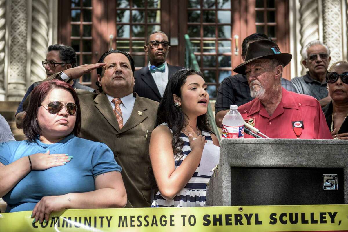 Isabel Sanchez, 12, sings the national anthem on the steps of City Hall as several San Antonians call for City Manager Sheryl Sculley to give interim Police Chief Anthony Trevino the job fulltime.