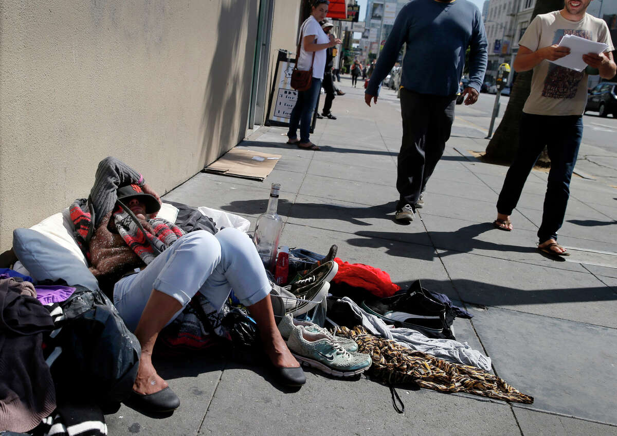 Above, a woman slept near the corner of Mission and Sixth streets as she displayed clothing for sale.