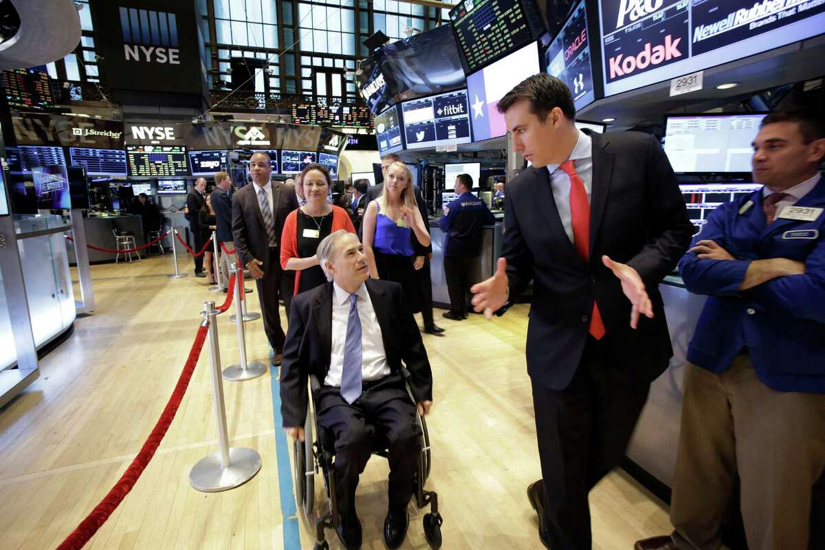 Texas Gov. Greg Abbott, center, gets a tour of the New York Stock Exchange with John Tuttle, second from right, head of corporate affairs with the exchange, Tuesday, July 14, 2015. The Republican governor is making New York the first stop on his plans to travel around the U.S. and world to woo companies to Texas. (AP Photo/Mark Lennihan)