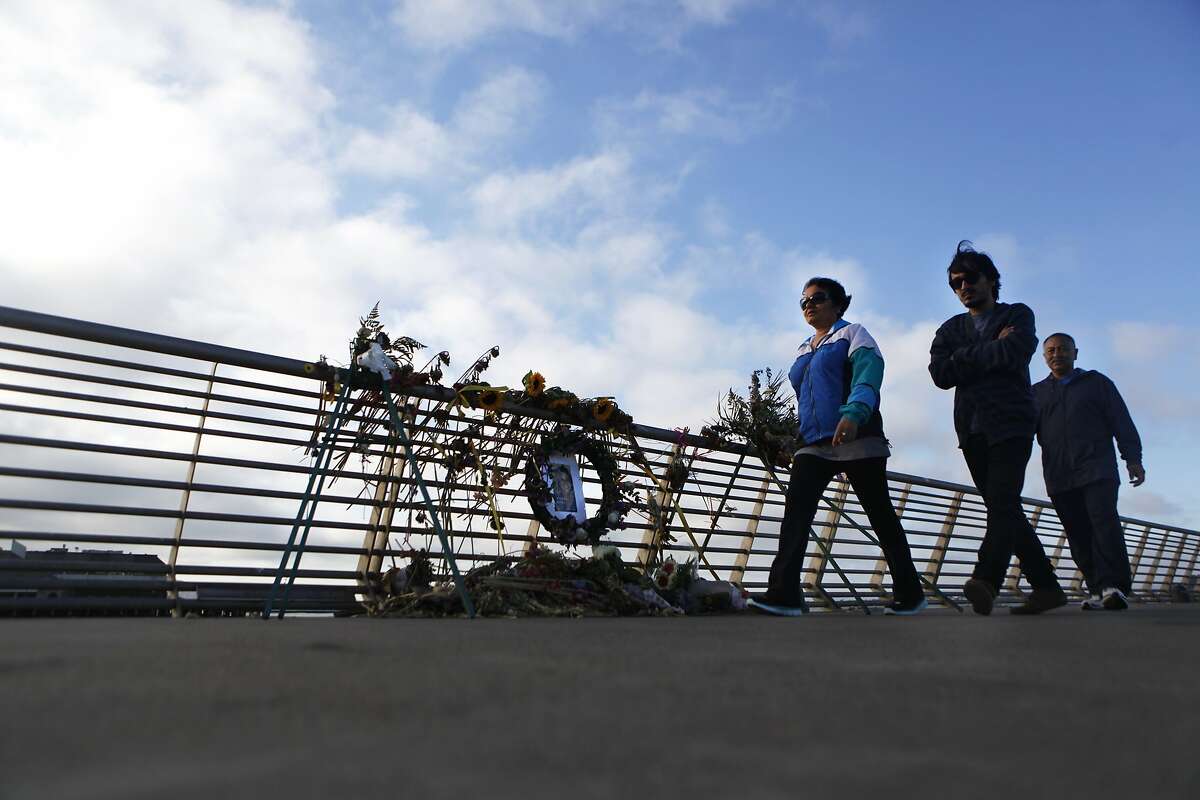 Ashok Karki, Anju Paudel and Apar Karki pass by the Pier 14 memorial for Kathryn Steinle who was fatally shot on July 1 as she walked along the pier with her family.