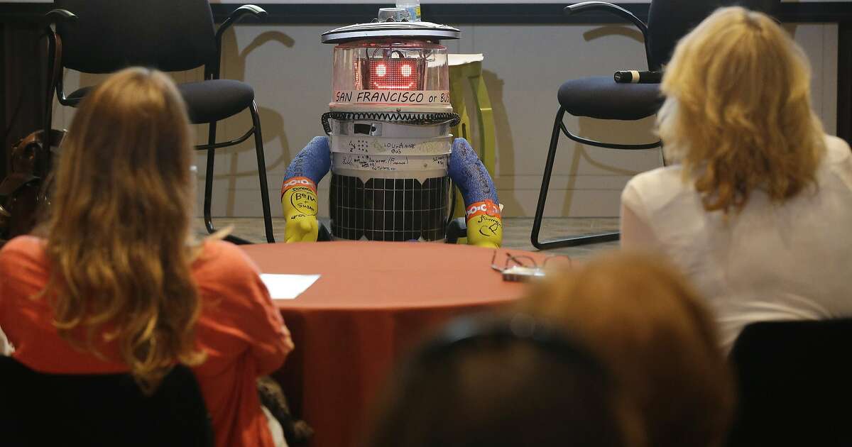 HitchBOT, a hitchhiking robot, is formally introduced to an American audience, during a program at the Peabody Essex Museum Thursday, July 16, 2015, in Salem, Mass. HitchBOT is set to embark on its' first cross-country hitchhiking trip of the U.S., after completing similar tips in Canada and Europe. The plans are for hitchBot to leave the Boston area Friday with a final destination goal of reaching San Francisco. (AP Photo/Stephan Savoia)