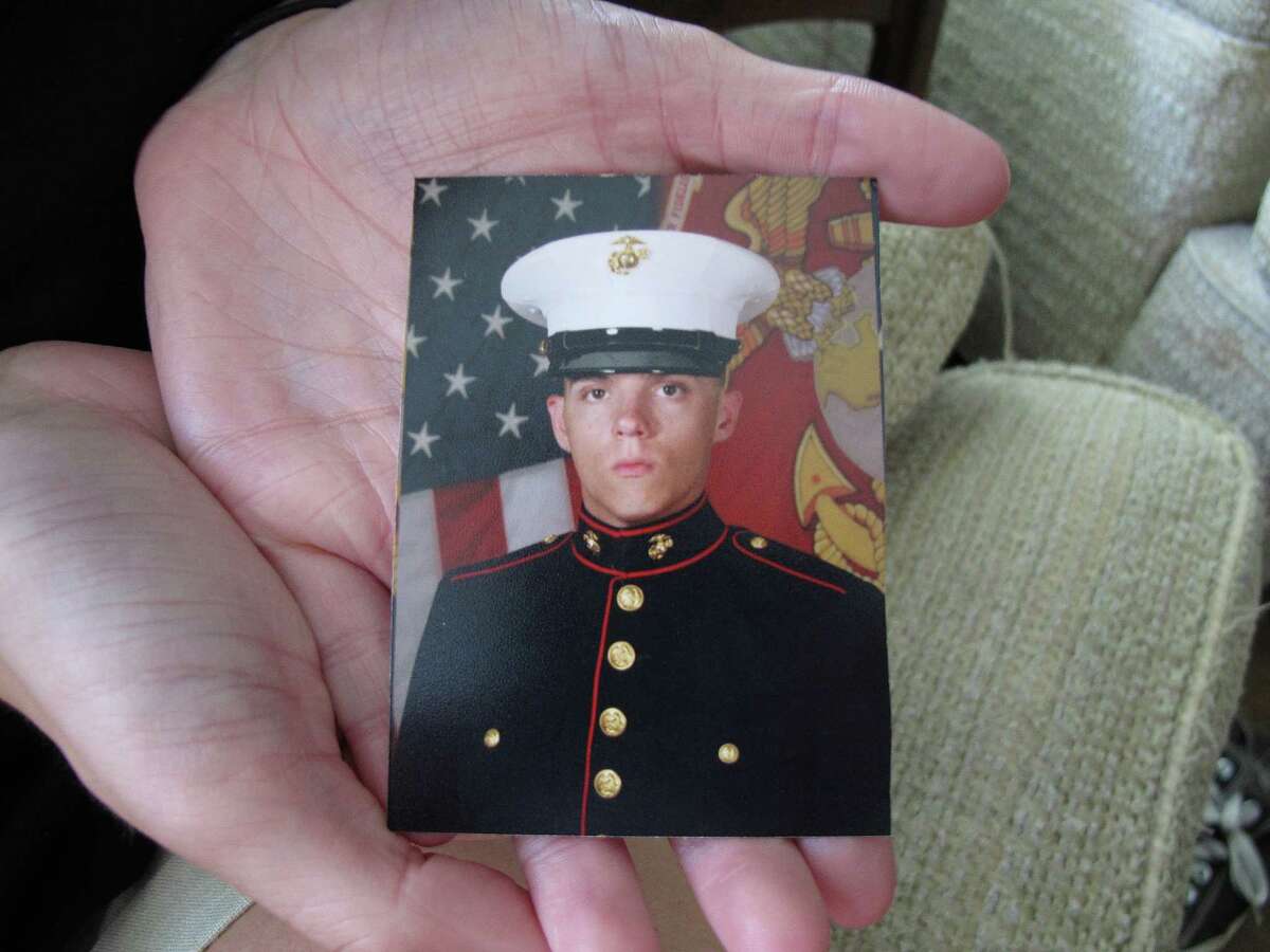 Caroline Dove holds a photo of Marine Corps Lance Cpl. Skip Wells, her boyfriend, in her hands July 17, 2015, at her home in Savannah, Ga. Wells was among four Marines killed July 16, 2015, in an attack at a military training facility in Chattanooga, Tenn. Muhammad Youssef Abdulazeez opened fire Thursday, July 16, 2015, on two U.S. military sites in Chattanooga in an attack that left four Marines dead and raised the specter of terrorism on U.S. soil. He was killed by police.(AP Photo/Russ Bynum)