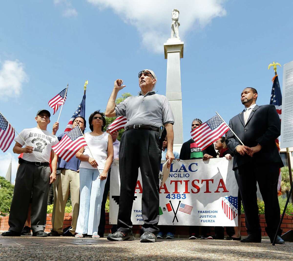 Mario Salas of San Antonio Coalition of Human and Civil Rights (center), Bexar County 4th Precinct Commissioner Tommy Calvert (right) and others gather for a press conference to demand the Confederate monument at Travis Park be removed in light of recent efforts by Bexar County officials to take down confederate symbols on public property. Since the park is on city property, the city council would have to vote and approve such a decision. Salas and Calvert hope to persuade their city officials to take such action. The monument has been at the park since 1899 which has a statue of a confederate soldier facing South and the words, "Our Confederate Dead" and "Lest we forget" engraved on the monument. (Kin Man Hui/San Antonio Express-News)