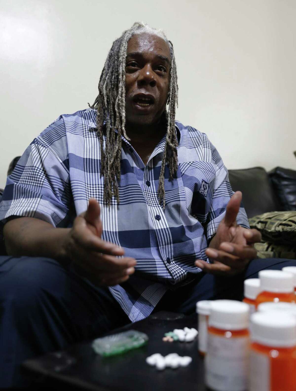 In this Monday, July 13, 2015 photo Earl Charles Williams Sr., 59, talks about the medication he must take for his diabetes in his Chicago home. Williams was uninsured for about a year before a county-run clinic helped him sign up for care under the Affordable Care Act. More than a dozen states that opted to expand Medicaid under the Affordable Care Act have seen enrollments surge way beyond projections, raising concerns that the added costs will strain their budgets when federal aid is scaled back starting in two years. (AP Photo/Christian K. Lee)