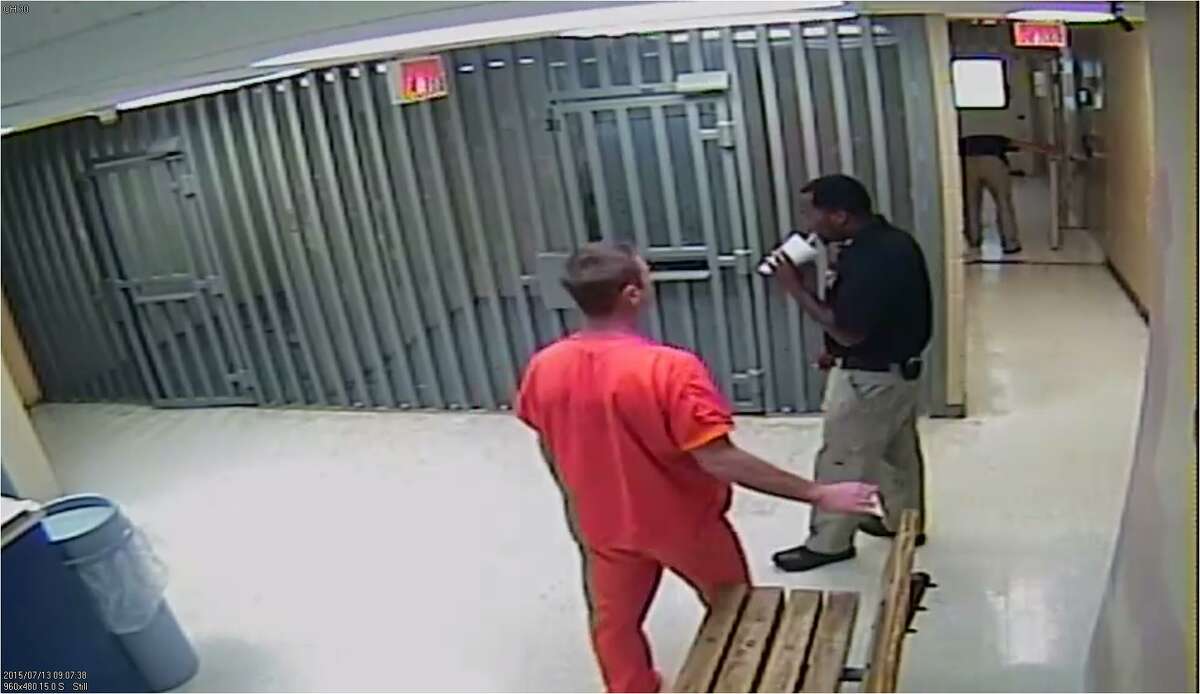 Video still from Waller County Jail, June 13, 2015: Female officer bends down, right background, to check on the female inmate (Sandra Bland) in Cell 95.