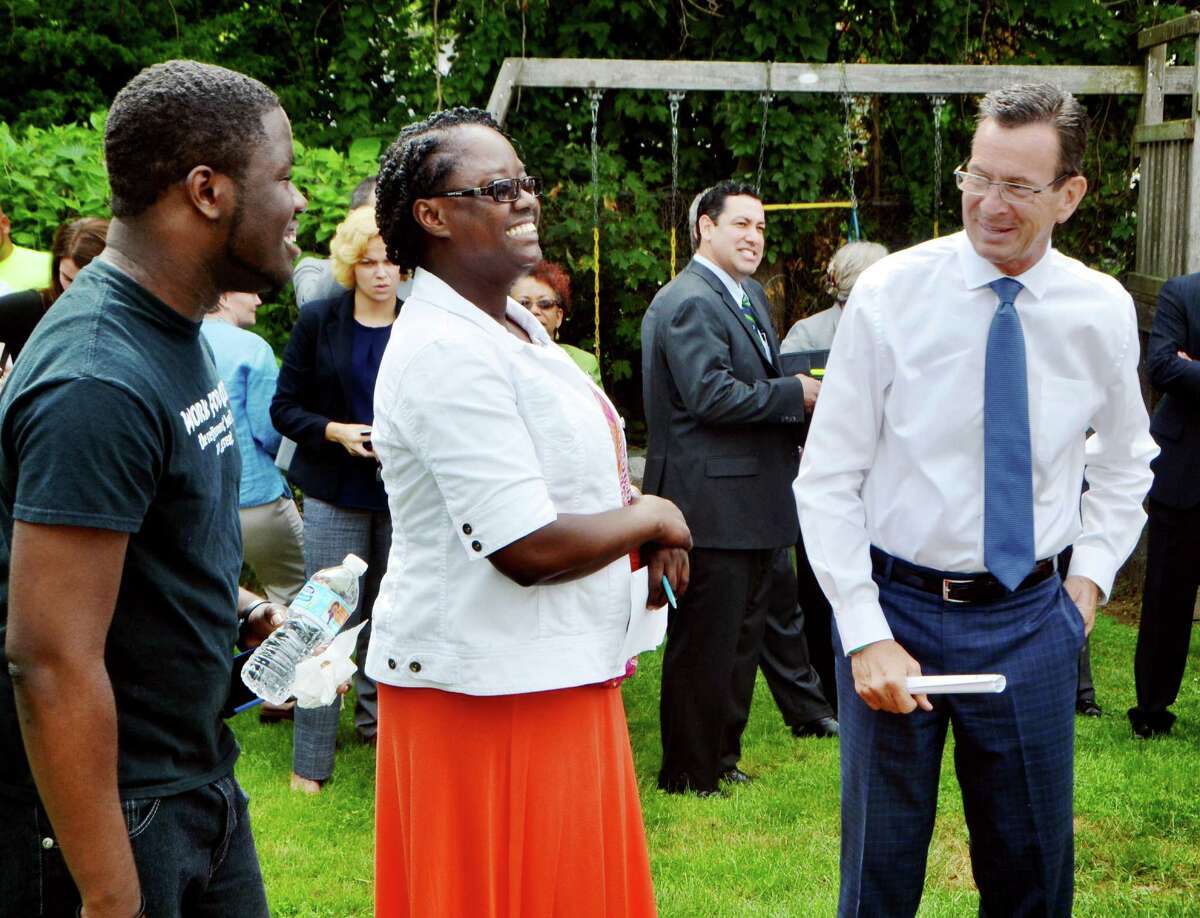 Susan Young and her son, Jason talk with Gov. Dannel Malloy before he spoke at her home in Bridgeport, Conn. on the partnership between The Connecticut Green Bank and PosiGen that provides incentive for homeowners that participate in their energy-saving program. The event, held in Young's backyard on Tuesday, July 21, 2015, highlighted the benefits her own household has seen by installing solar and other energy efficiency measures.