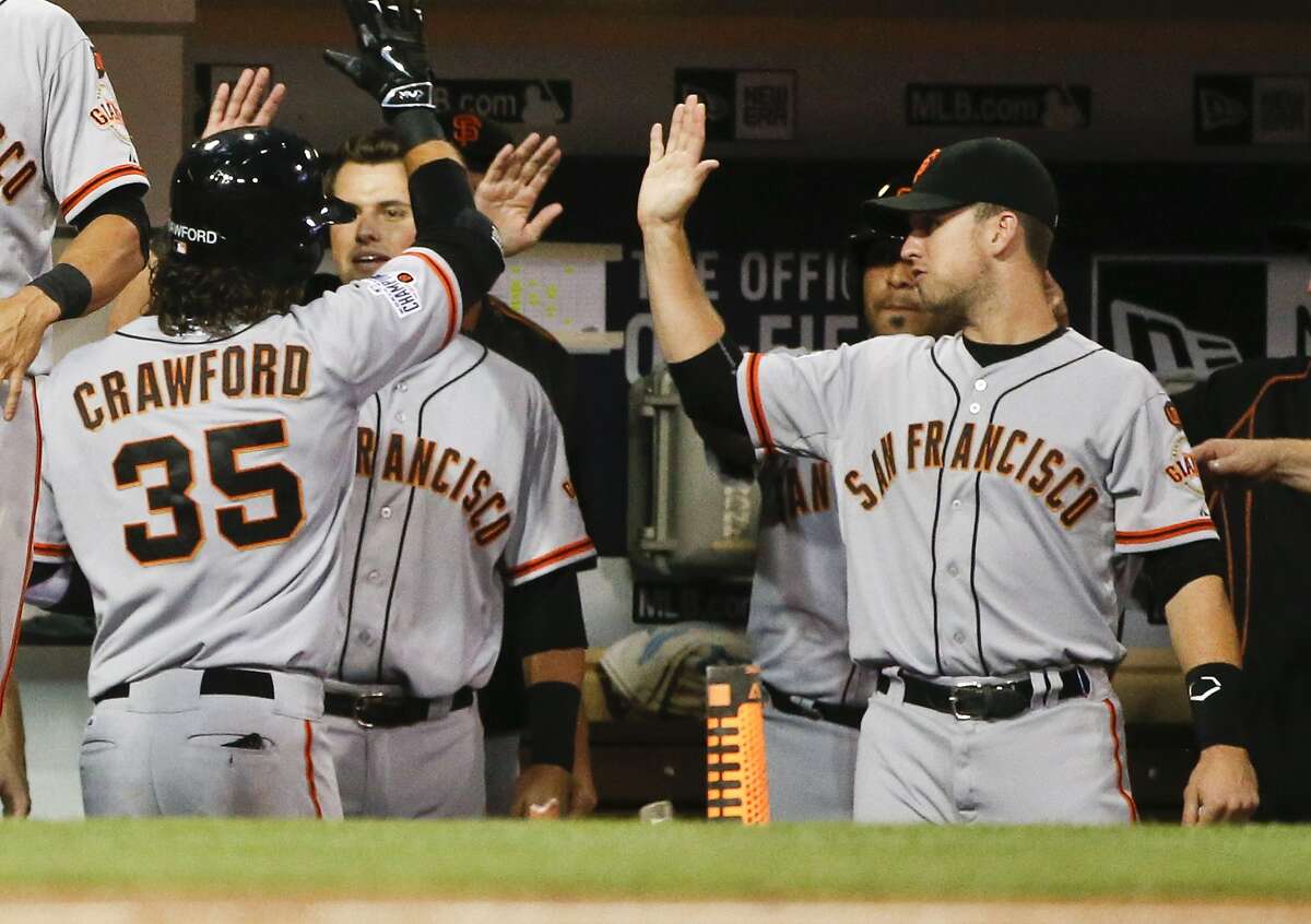 San Francisco Giants' Brandon Crawford is congratulated at the dugout after his three run homer against the San Diego Padres in the fourth inning of a baseball game Tuesday, July 21, 2015, in San Diego. (AP Photo/Lenny Ignelzi)