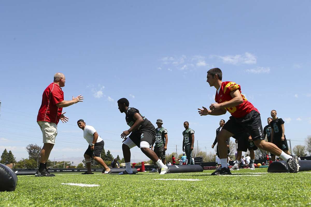 From left: Terry Summerfield, regional master trainer for USA Football's "Heads Up Football" program, runs a drill with De La Salle's Boss Tagaloa, Deer Valley's Troy Decuir and Jesuit's Theo Christopulos during High School Football Media Day at Levi's Stadium in Santa Clara, CA, on Wednesday, July 22, 2015. The event was hosted by the San Francisco 49ers, USA Football and MaxPreps. USA Football's Heads Up Football program is a national initiative to make the sport safer.