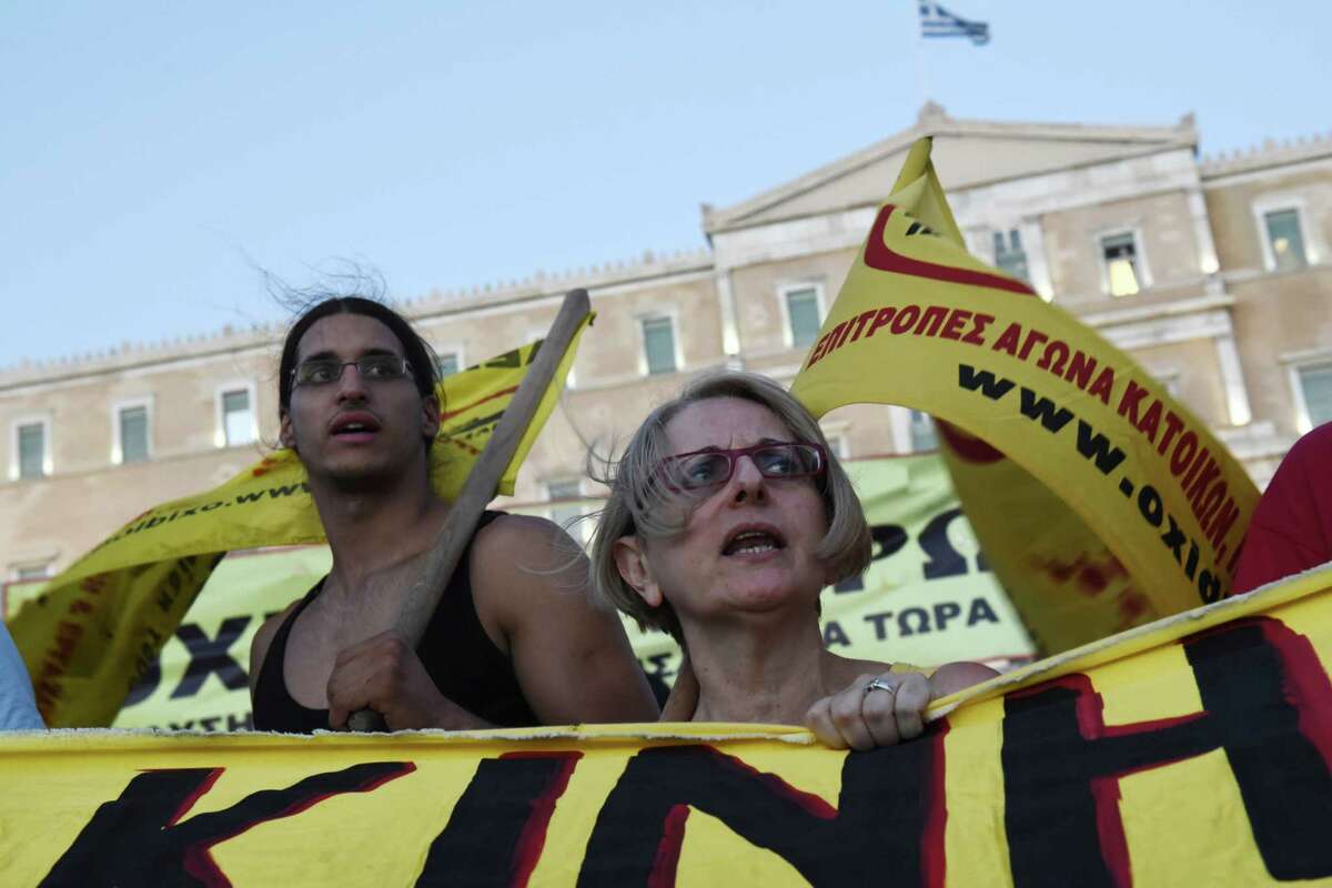 Demonstrators shout slogans outside the Greek Parliament during an anti-austerity rally in Athens, Wednesday, July 22, 2015. Barely a week after their last crunch vote, Greek lawmakers are set to vote later Wednesday on further economic reforms demanded by international creditors in return for a new financial bailout. (AP Photo/Giannis Papanikos)