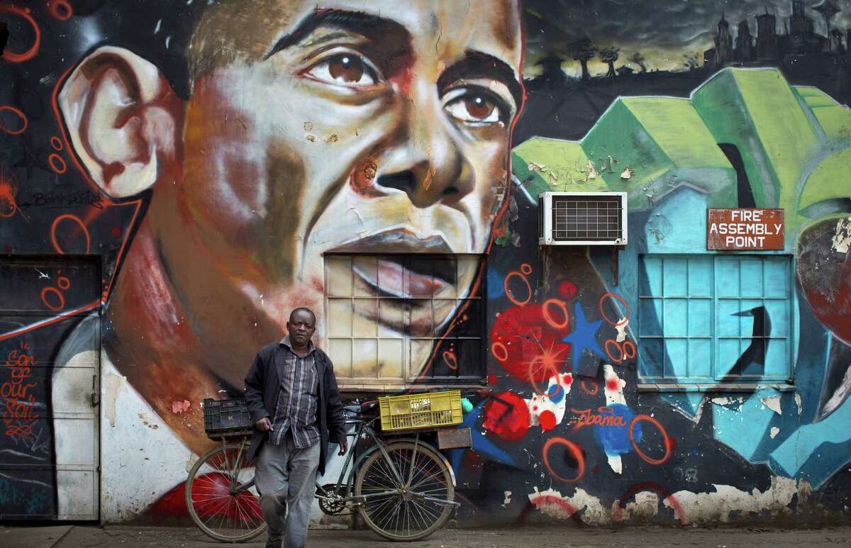 A man walks away after leaning his bicycle against a mural of President Barack Obama, created by the Kenyan graffiti artist Bankslave, at the GoDown Arts Centre in Nairobi, Kenya Wednesday, July 22, 2015. In his first trip to Kenya since he was a U.S. senator in 2006, Obama is scheduled to arrive in Kenya on Friday, the first stop on his two-nation African tour in which he will also visit Ethiopia. (AP Photo/Ben Curtis)