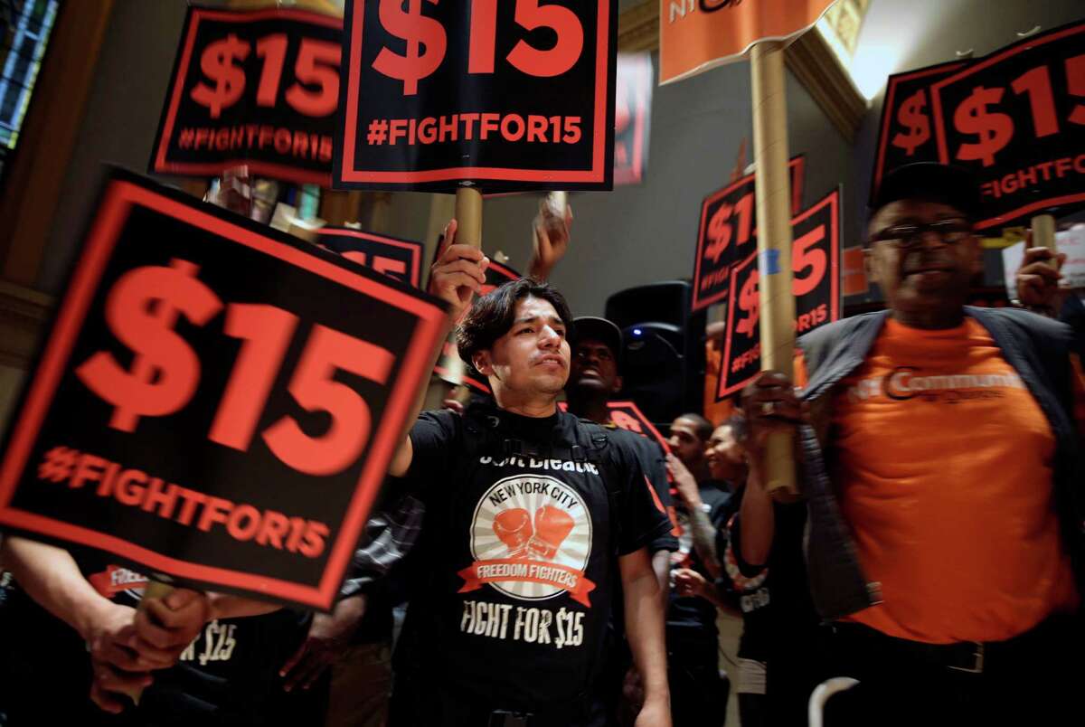FILE - In this June 15, 2015, file photo, demonstrators rally for a $15 minimum wage before a meeting of the state Wage Board in New York. The New York state Wage Board is expected to recommend a higher minimum wage for the industry during a meeting Wednesday, July 22, 2015, in New York City. Board members say they support an increase, though they havenât offered a specific amount. (AP Photo/Seth Wenig, File)