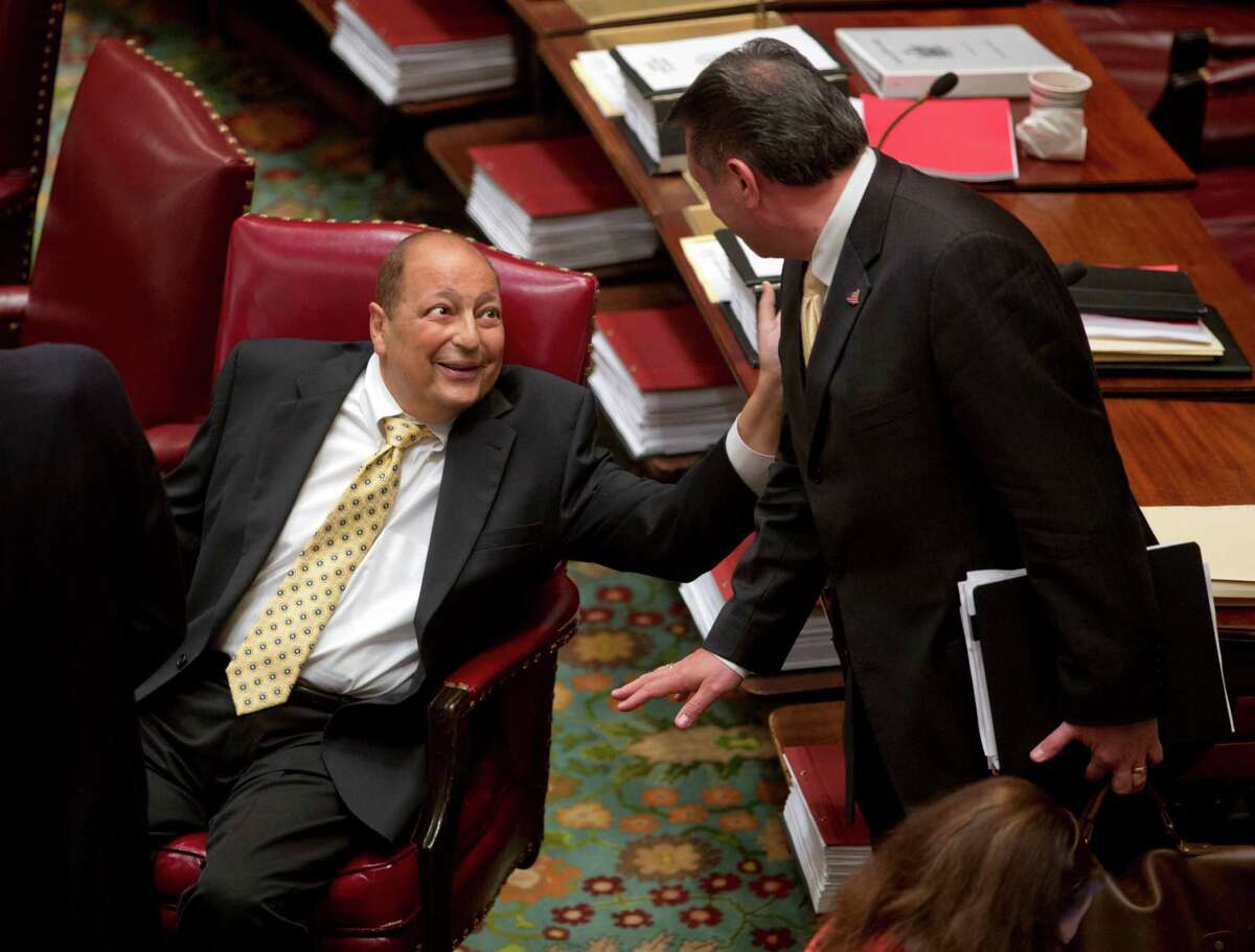 FILE - In this June 16, 2015 file photo, New York State Sen. Thomas Libous, R-Binghamton, left, talks with Sen. Joseph Addabbo Jr, D-Howard Beach, during the legislative session in Albany, N.Y. Libous, the No. 2 Republican in the New York state Senate, has been convicted of lying to the FBI about arranging a high-paying job for his son. Under state law, the felony conviction means Thomas Libous loses his seat. (AP Photo/Mike Groll, File)