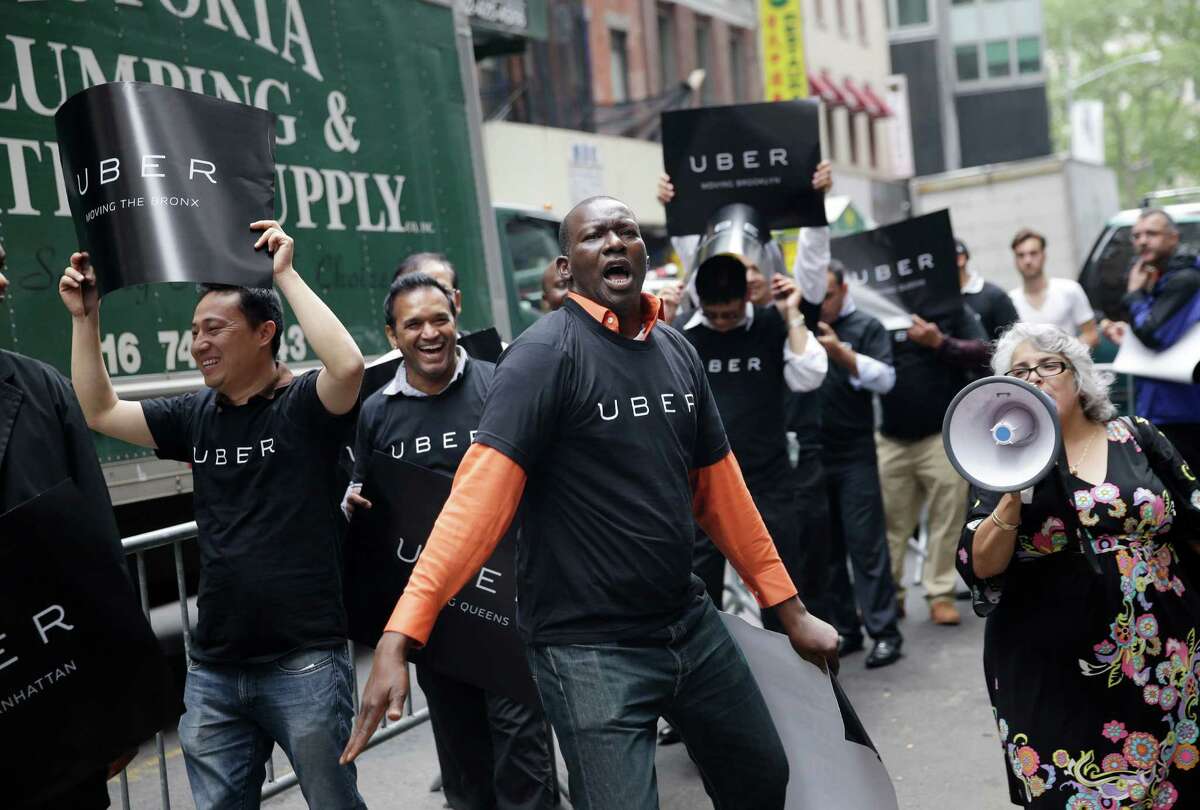 Uber drivers and their supporters protest in front of the offices of the Taxi and Limousine Commission in New York on May 28, where a proposal before the commission would require car services that riders can summon with their phones to comply with many of the rules that govern the yellow cabs they compete with. (AP Photo/Seth Wenig)