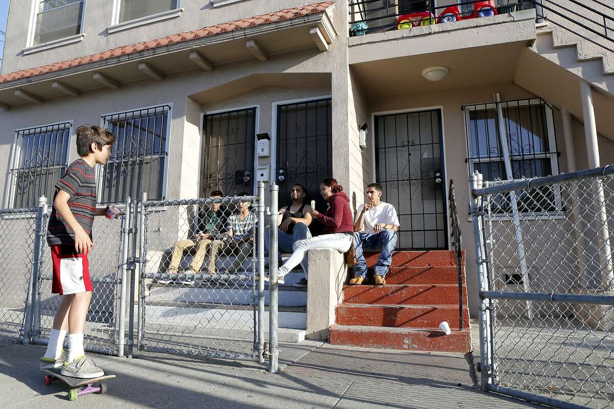 Neighbors Jose Ibarra, Manuel Ibarra, Gabriel Vargas, Guillermo Vargas, Cindy Torres and Daniel Vargas (left to right) hang out around the apartment where police say a man imprisoned and assaulted a woman for a year in Richmond, California, on Wednesday, July 22, 2015.