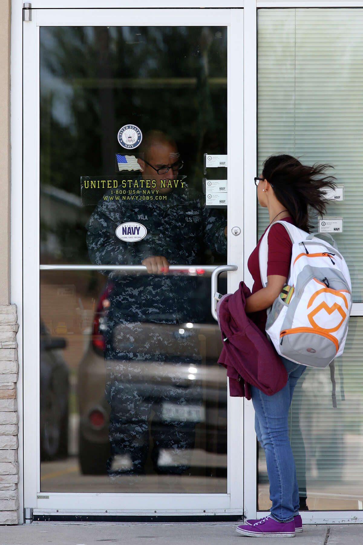 A recruiter opens a locked door on Wednesday at the U.S. Navy recruiting office in the Armed Forces Career Center in McAllen﻿.