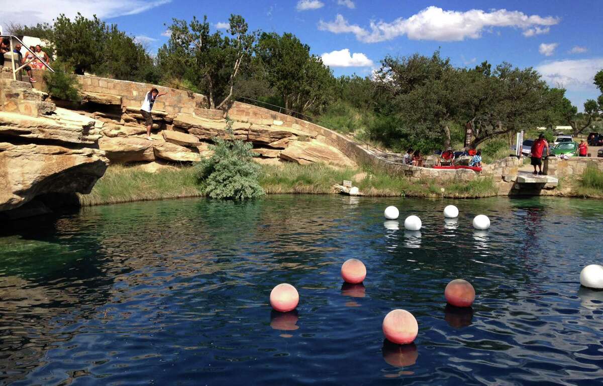 A boy leaps into the water at Blue Hole State Park in Santa Rosa, N.M. Blue Hole is part of the New Mexico Tourism Department's "New Mexico True" campaign, an effort aimed at drawing more tourists to the state.