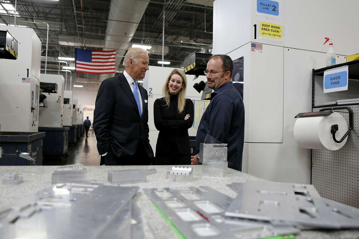 Vice President Joe Biden speaks with Elizabeth Holmes (center), CEO of Theranos, and employee Tim Cooper during a tour of a Theranos production facility in Newark, California, on Thursday, July 23, 2015.