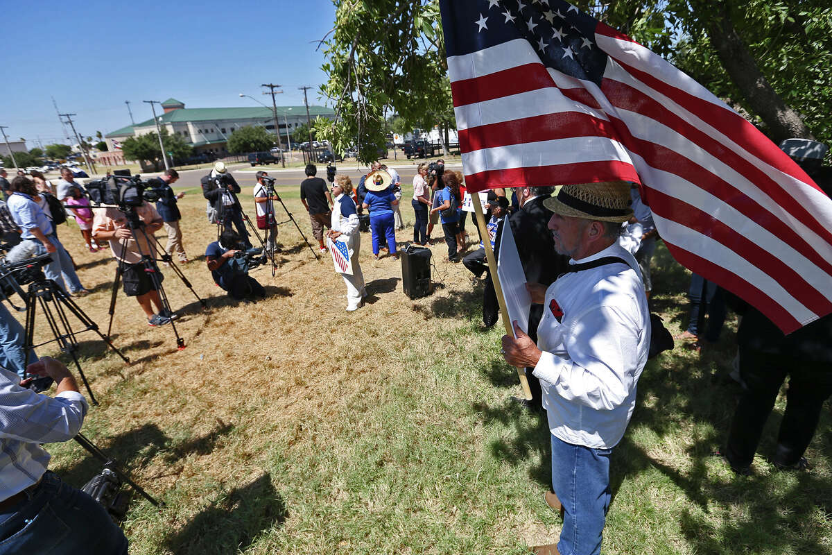 Protestors gather outside a private hanger while waiting for the arrival of Republican primary presidential candidate Donald Trump in Laredo, Thursday, July 23, 2015. At an event center, Trump talked to a group of law enforcement personnel drawing loud cheers of support from the crowd.