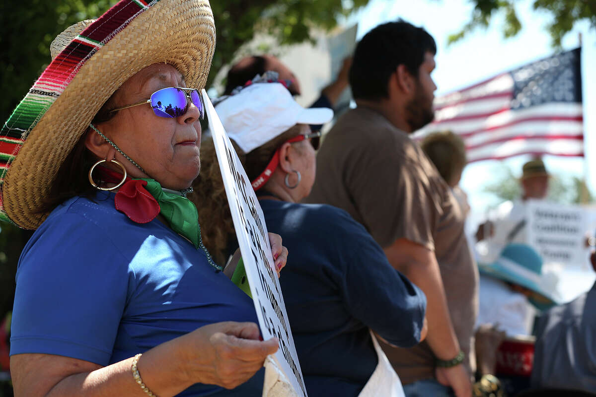 Lourdes Galvan, of San Antonio, joins other protestors outside a private hanger while waiting for the arrival of Republican primary presidential candidate Donald Trump to Laredo, Thursday, July 23, 2015. At an event center, Trump talked to a group of law enforcement personnel drawing loud cheers of support from the crowd.