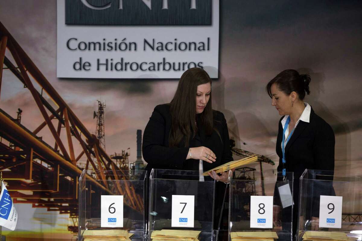 Representatives from oil production companies deliver their bids to the National Hydrocarbons Commission.