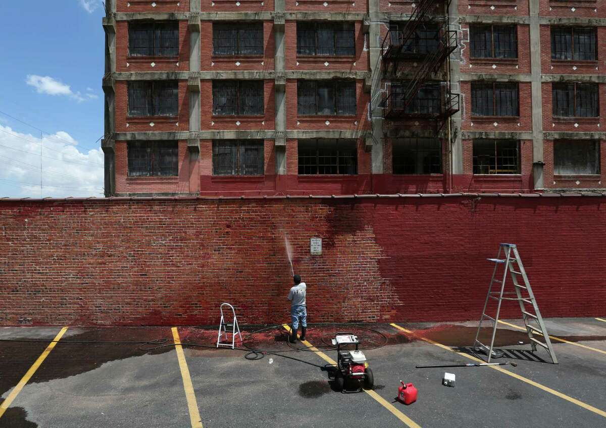 A worker power-washes the former Cheek Neal Coffee Building, at 2017 Preston, is seen Friday, July 24, 2015, in Houston. The building was acquired by Houston developers who plan to restore it. ( Jon Shapley / Houston Chronicle )