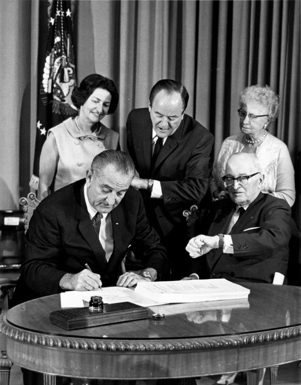 ﻿President Lyndon B. Johnson, left, signs the Medicare Bill, a signature piece of legislation that he touted as a 'blessing for older Americans.'﻿