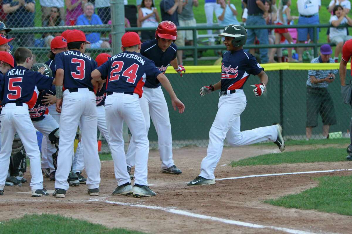 Stamford North’s Jaden Dawkins is greeted by teammates following his two run homer in the bottom of the second inning against Hamden in a Division 1 Little League semifinal championship game in Stamford on Saturday, June 25, 2015. Stamford North defeated Hamden 14-4, advancing to Sunday’s championship final against Fairfield American.