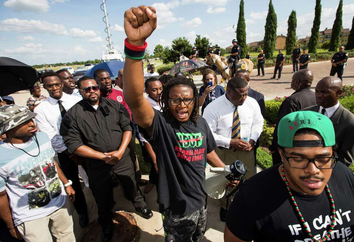 Malik Muhammad, raises his fist during a protest calling for the firing and indictment of State Trooper Brian Encinia on Sunday, July 26, 2015, in Katy. The demonstrators gathered at an apartment complex, lined by Harris County deputies on horseback, to protest against the trooper who arrested Sandra Bland.