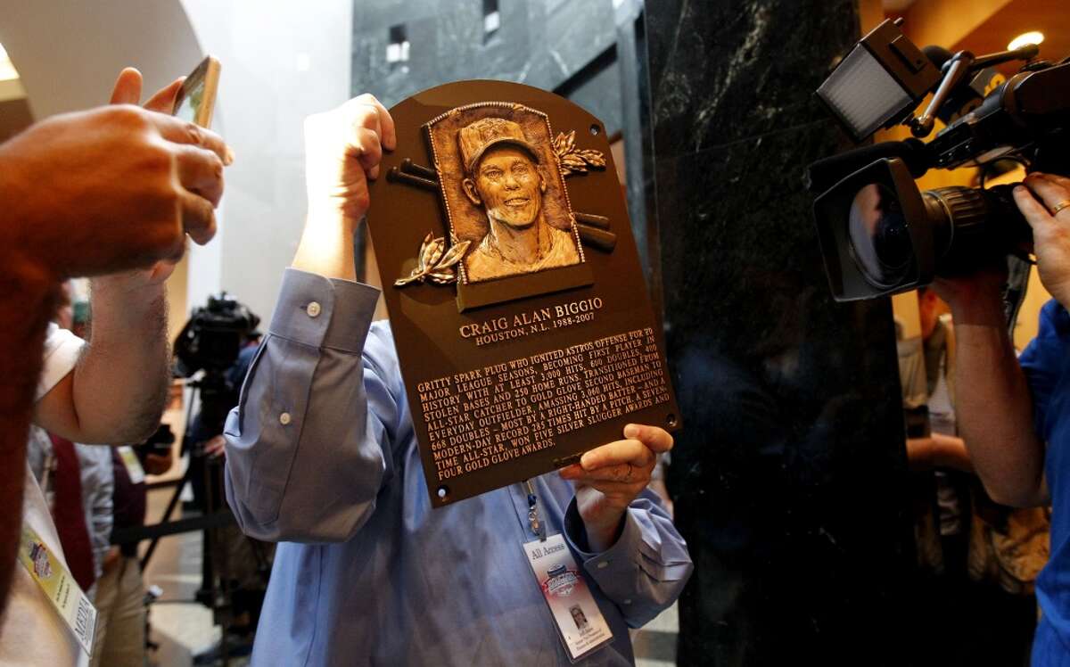 A Baseball Hall of Fame employee walks Craig Biggio's Hall of Fame plaque through the horde of cameras and into its spot in the museum, Sunday, July 25, 2015, in Cooperstown NY. (Karen Warren/Houston Chronicle)