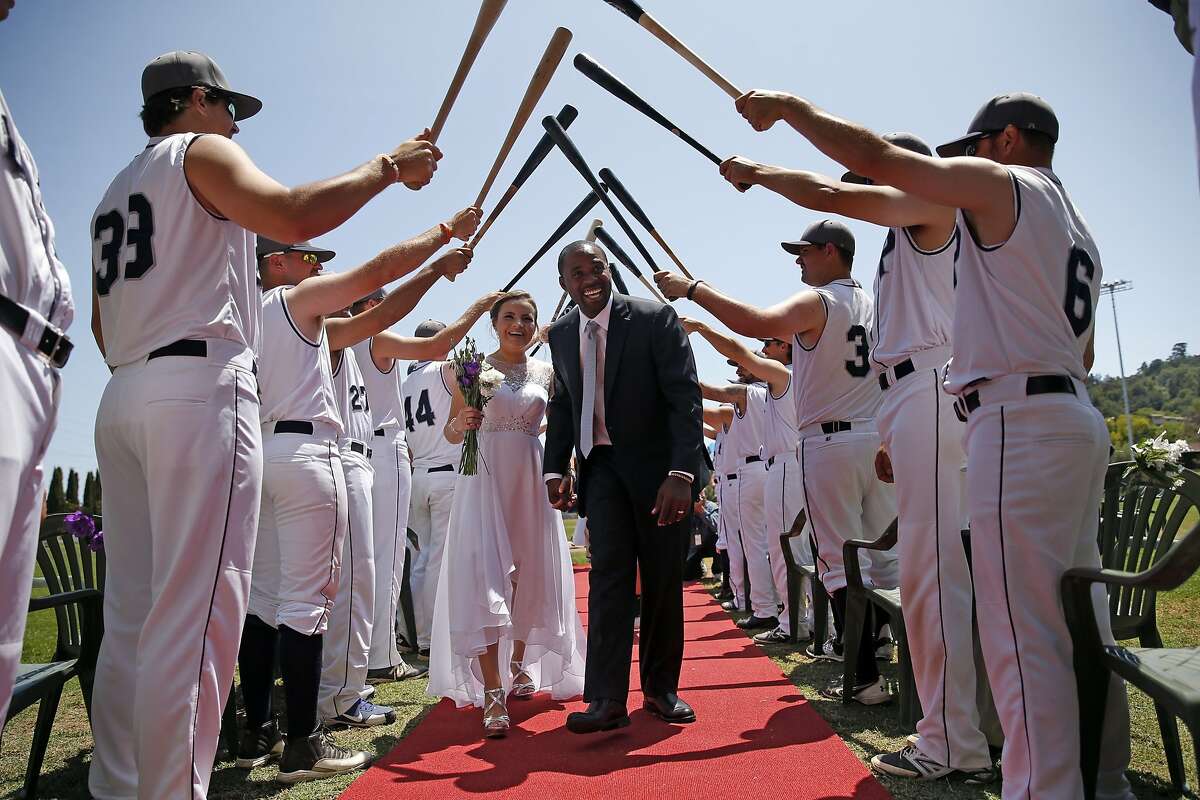San Rafael Pacifics' Maikel Jova and Diany Lomeli walk back down a red carpet after being married by Pacifics' manager Matt Kavanaugh before the team's minor league baseball game at Albert Field in San Rafael, Calif., on Sunday, July 26, 2015.