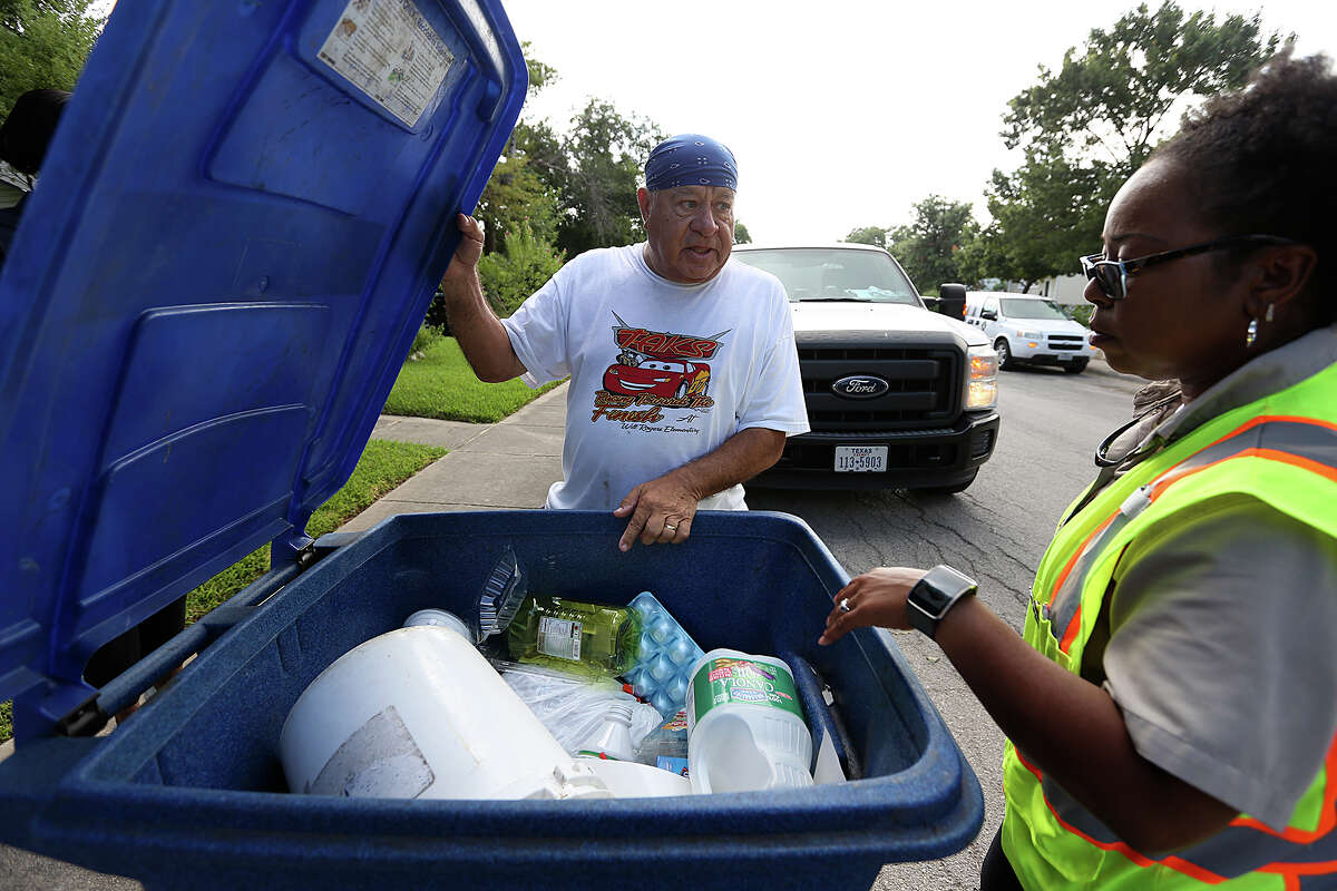 San Antonio Solid Waste Department route inspector Asia Jones-Carr talks with a homeowner as she inspects recycling cans for unauthorized items such as household garbage and air conditioning filters. No such items were found in this recycling can, but a reader laments the fact that many recycling cans do contain trash.