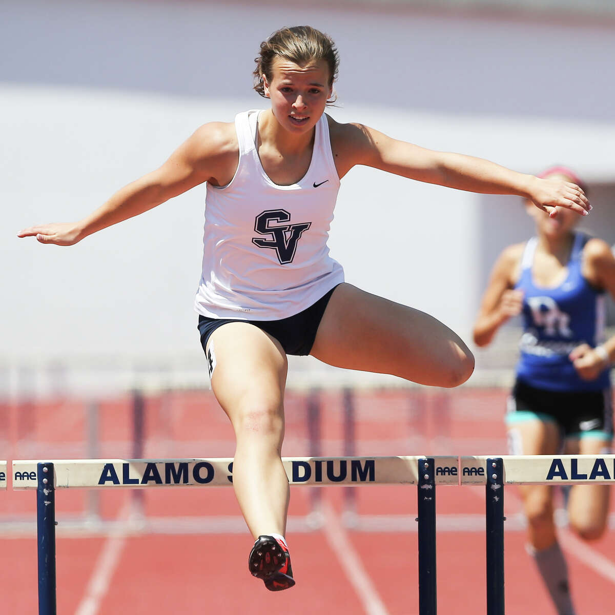 Smithson Valley’s Olivia Pappas clears the final hurdle of the 6A 300-meter hurdles during the Region IV-5A and Region IV-6A Track and Field meet at Alamo Stadium on Saturday, May 2, 2015. Pappas won the event with a time of 43.61 seconds.