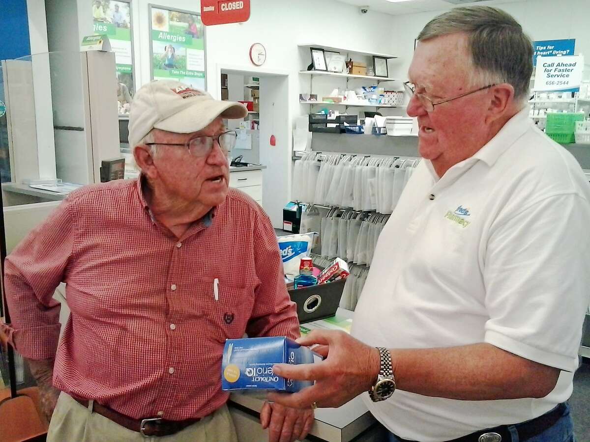 ADVANCE FOR SUNDAY, JULY 26, 2015 In this June 25 2015 photograph, Philadelphia, Miss., resident, Barney Shepherd, left, gets help from part-time Fred's pharmacist, Donny Kitchens. Shepherd, a Medicare recipient, has seen the price of his diabetic testing strips spike in recent weeks. (Monica Land/The Clarion-Ledger, via AP)