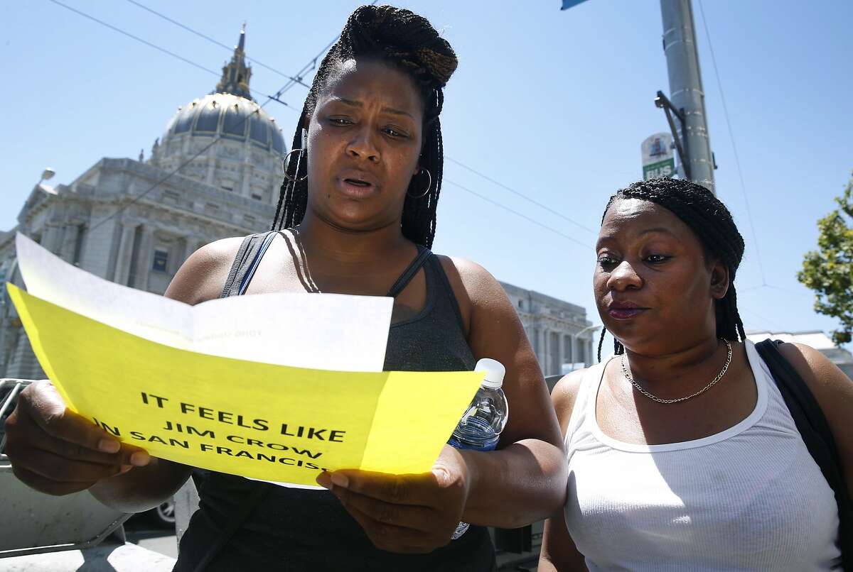 Residents Shronda Jackson (left) and Pamela Cooper read updates about possible evictions from their homes outside of the SF Superior Courthouse in San Francisco, Calif. on Tuesday, July 28, 2015. The Third Baptist Church asked a Superior Court judge to issue a restraining order against the landlord of the Frederick Douglas Haynes Gardens low income apartments from selling the property to speculators.