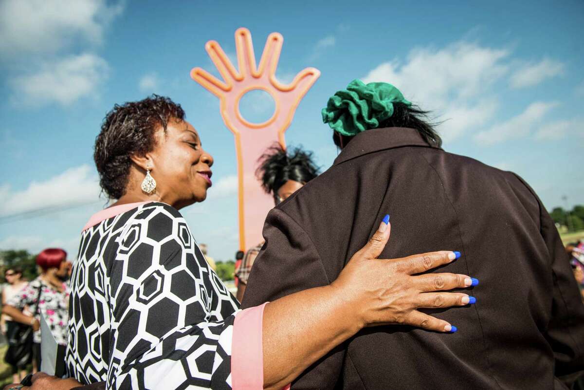 Cynthia Hornsby, former executive director of the Davis-Scott YMCA and current volunteer, left, talks to Beverly Watts of the San Antonio Housing Authority, right, at the dedication of the new "Open Hand, Open Mind, Open Heart," art piece at Pittman-Sullivan Park in the East side neighborhood in San Antonio on Wednesday, July 29, 2015. The project is a collaboration between City Council District 2, the Department for CUlture and Creative Development's Public Art San Antonio, Transportation and Capital Improvements, Parks and Recreation, and the Davis-Scott Family YMCA. The committee commissioned Boston artist Douglas Kornfeld to create the 32-foot tall sculpture consisting of perforated steel and metal tubing, opening up the neighborhood to the city of San Antonio.