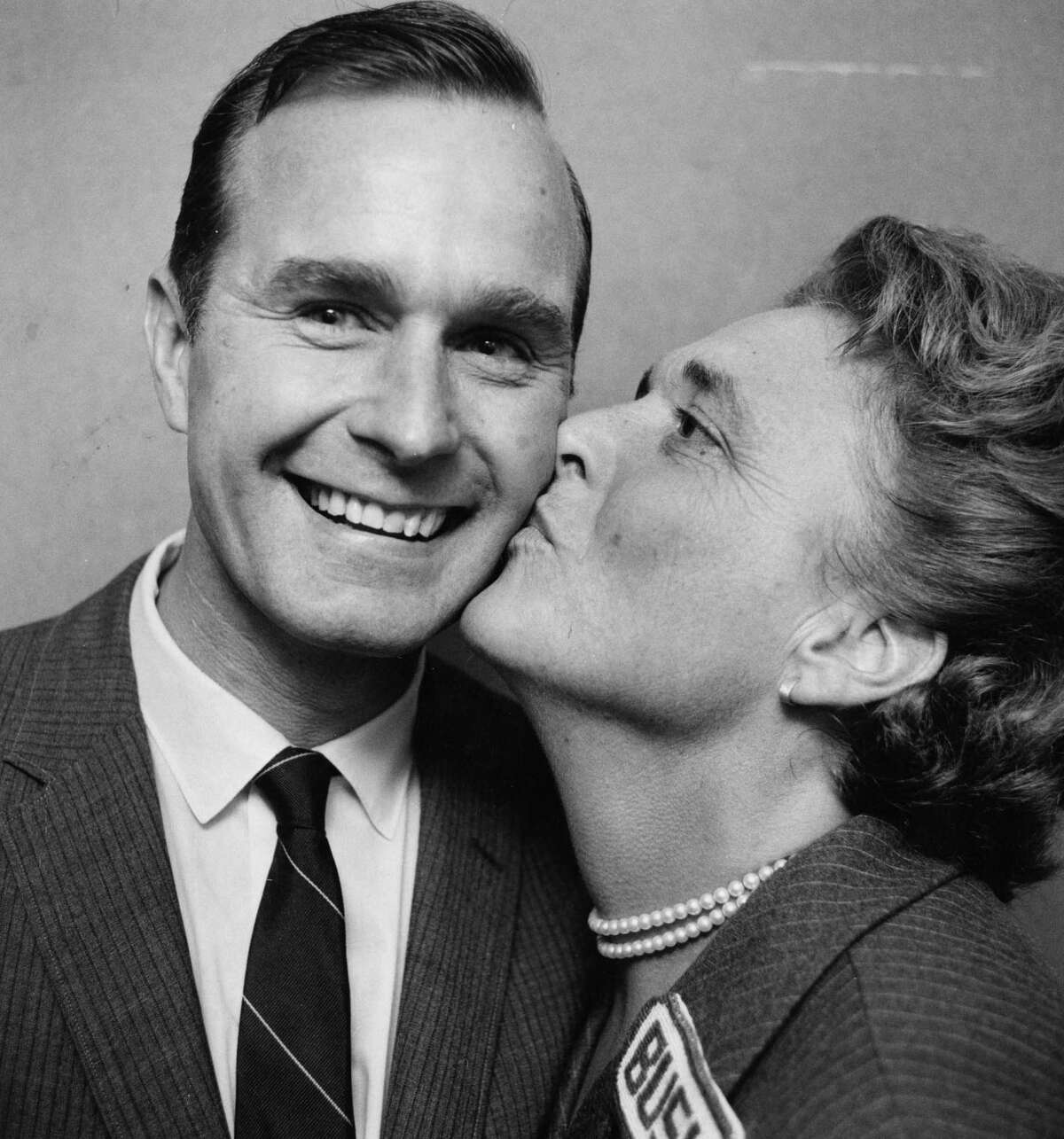 Newly-elected U.S. Rep. George Bush flashes a winner's smile as his wife, Barbara, gives him a victory kiss following his 1966 election to a seat in from the 7th district in Texas. See George and Barbara's love story told in photos.