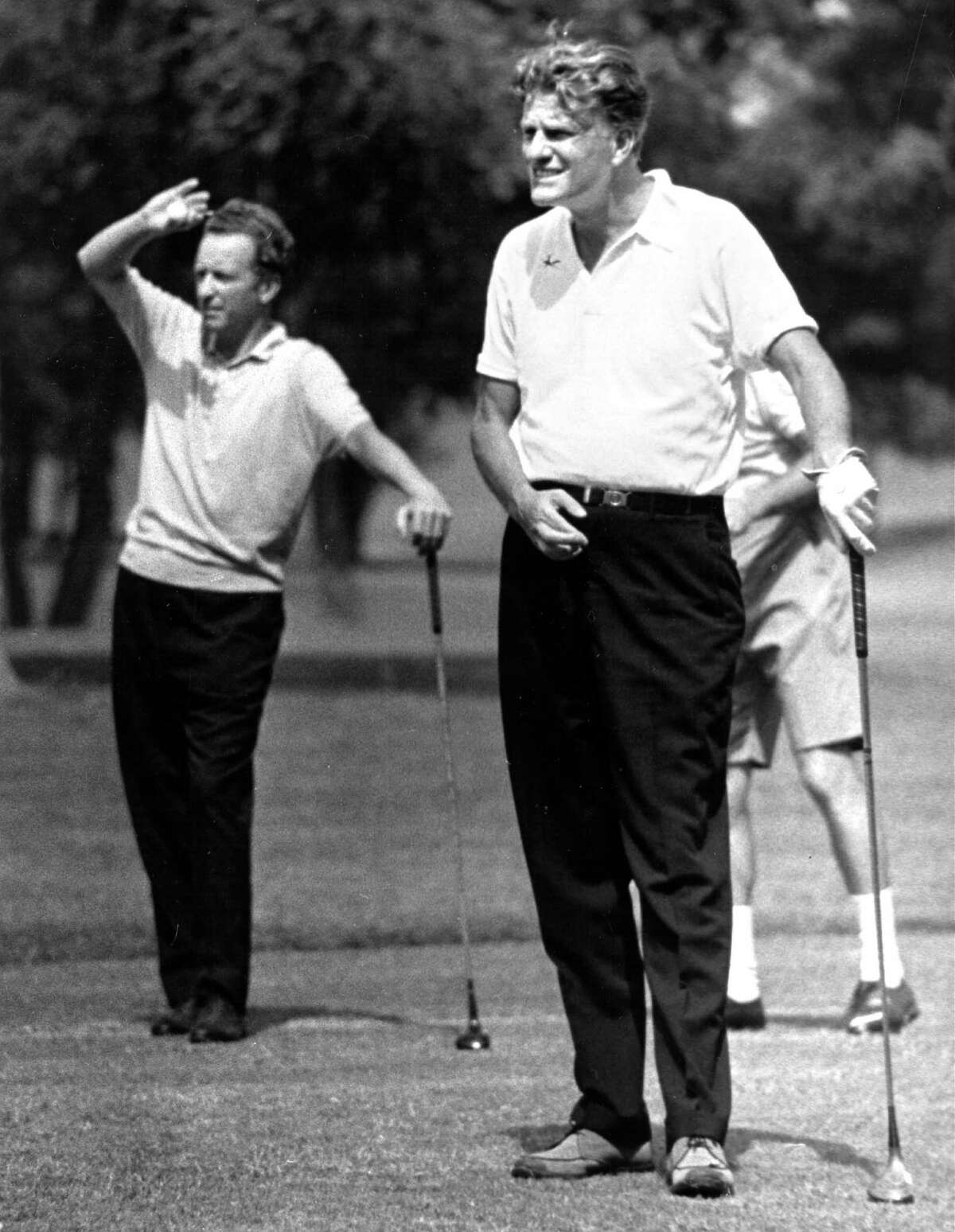 Billy Graham (right) watches his drive during a round of golf with Buckner Fanning while he was in San Antonio for the 1968 Crusade. At left is Buckner Fanning.