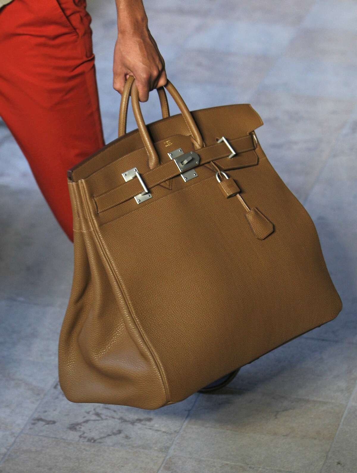 In the book "Primates of Park Avenue," by Wednesday Martin, the author uses anthropology to explain the tribal practices of mothers in the Upper East Side of New York, including their dress codes and which accessories carry the most status. The Birkin bag by Hermes is considered one of the most coveted handbags, starting at $8,000 for plain leather bag and running up to $150,000 or more for bags in crocodile or ostrich skin. (AP Photo/Jacques Brinon, 2011, File)