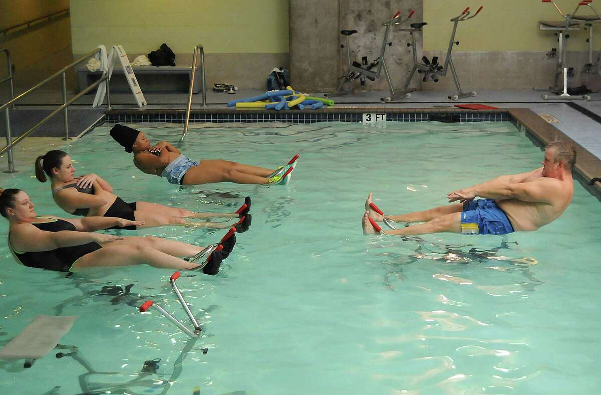 Tim Fletcher leads an aqua cycle class at the Downtown YMCA Monday July 13, 2015. (Dave Rossman photo)