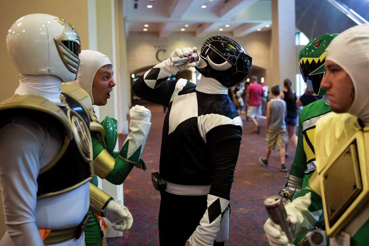 A group of San Japan attendees dressed as power rangers, including Nick Perez, left, Jeremy Cardosa, second the left, and Joe McCorkle, right, hang out in a hall of the Henry B. Gonzalez Convention Center during San Japan in San Antonio, Texas.