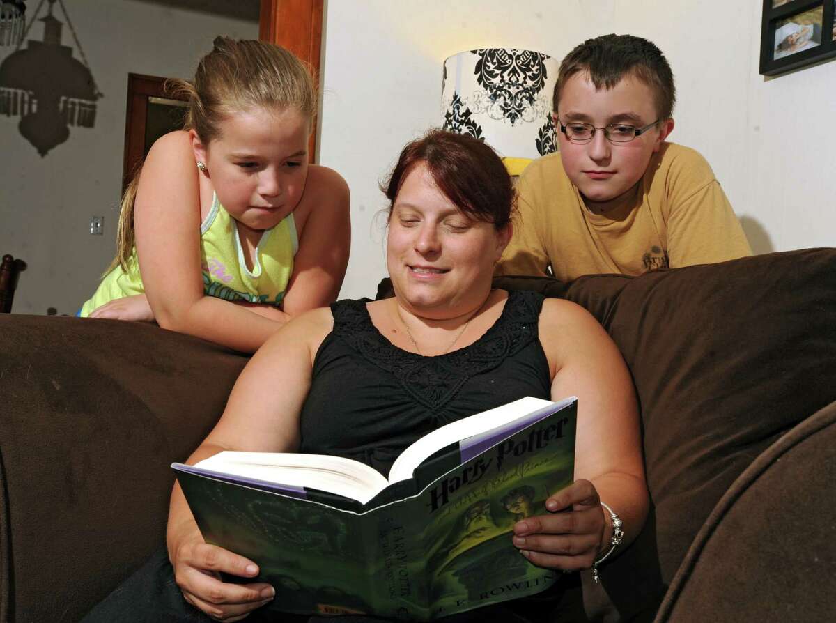 Simone Treffiletti reads with her kids Kadence, 11, left, and Tyler, 14, at their new home on Tuesday, July 28, 2015 in Lansingburgh, N.Y. (Lori Van Buren / Times Union)